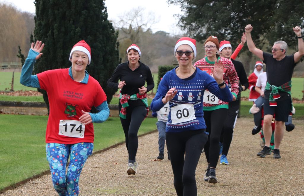 Festive Fun Run participants running the route, with smiling faces and festive attire.