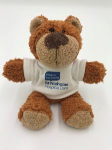 brown teddy bear wearing a st nic's t-shirt