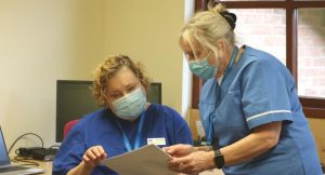 two hospice community team members looking at paperwork