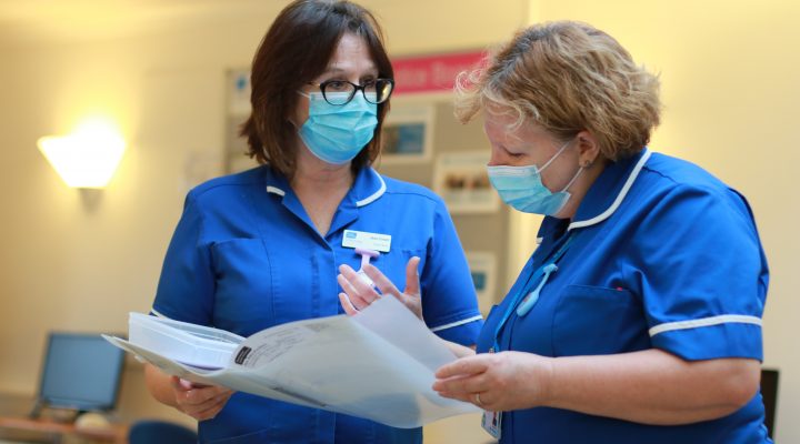 two hospice ward staff reading a file