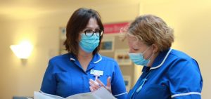 two hospice ward staff reading a file