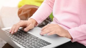 person hands on a laptop keyboard