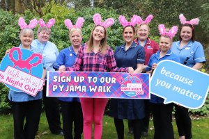 hospice staff gather together holding signs and banners to launch this year's girls night out walk