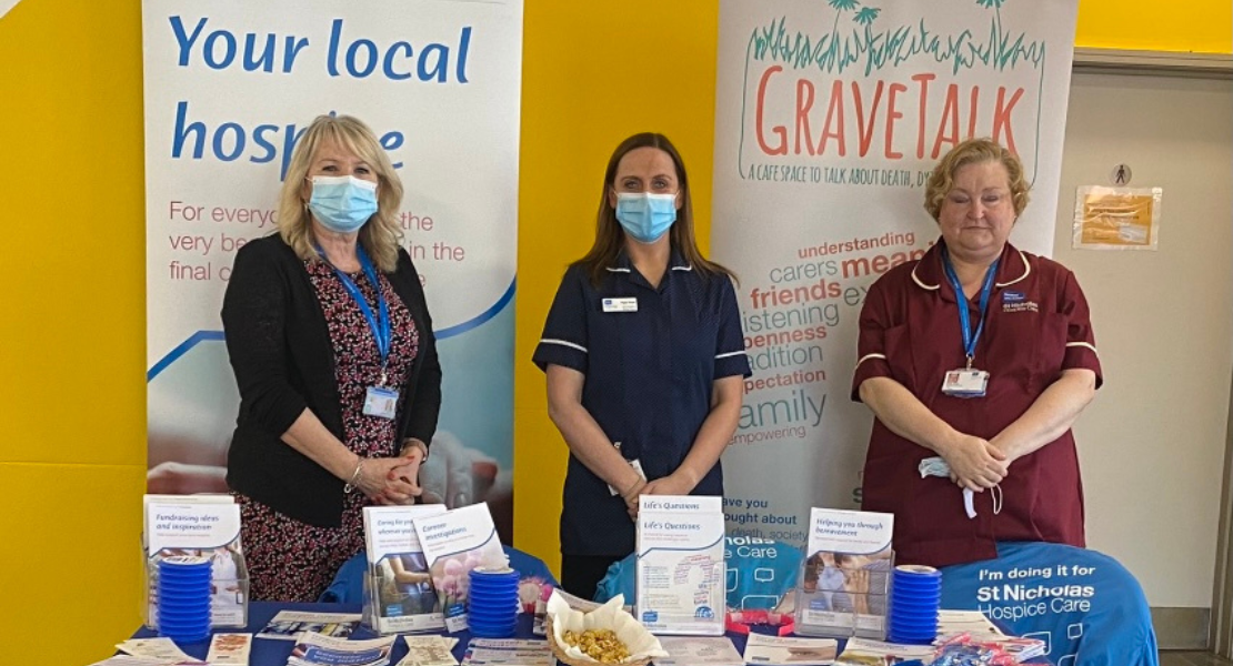 Members of the Hospice's education team stand behind a table of leaflets and information