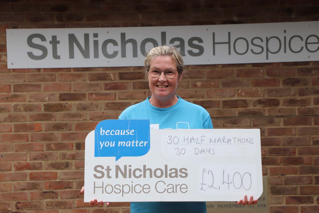 Image of Melanie Furness holding a cheque in celebration of her efforts for St Nicholas Hospice Care