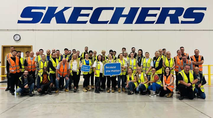 The team at Skechers in Bury St Edmunds, sponsors of the St Nicholas Hospice Care 10K Run 2024, standing under the Skechers sign