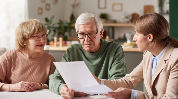 Photo showing three people sat looking at a Will