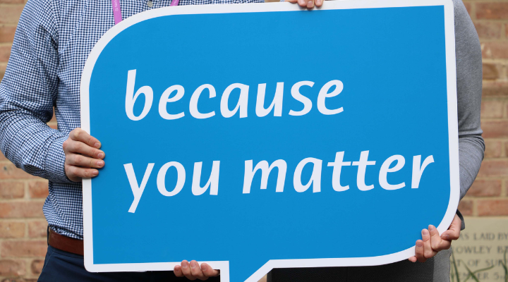 Two people holding the Hospice's Because You Matter sign