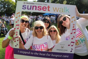 Sunset Walk participants smiling with a selfie board