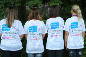 Four Sunset Walk participants with T-shirts with in memory messaging
