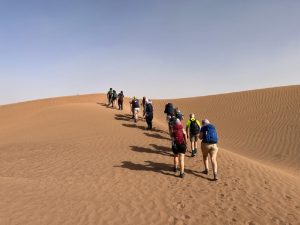 People trekking through the Sahara Dessert