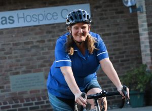 Hospice nurse on bike outside Hospice building