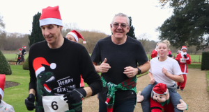 smiling runners wearing Christmas attire and Santa hats