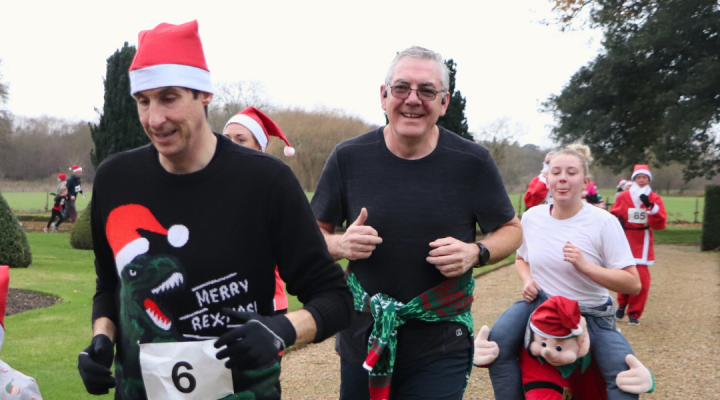 smiling runners wearing Christmas attire and Santa hats