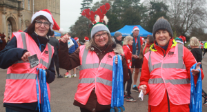 Smiling volunteers holding medals