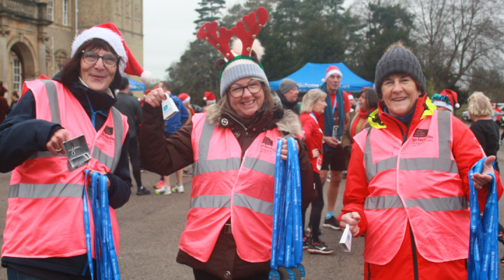 Smiling volunteers holding medals
