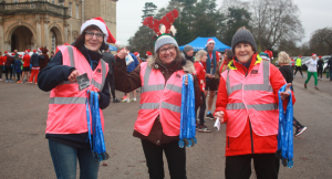 Smiling volunteers holding medals
