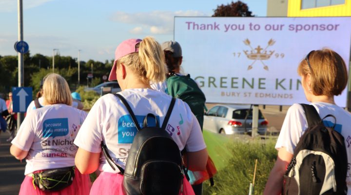Sunset Walk participants walking past the digivan with sponsor Greene King's logo