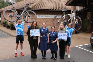 Hospice staff holding bikes and St Nic's Cycle Ride signs