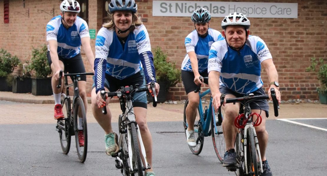 Cyclists wearing St Nic's jerseys outside the Hospice