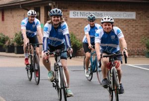 Cyclists wearing St Nic's jerseys outside the Hospice