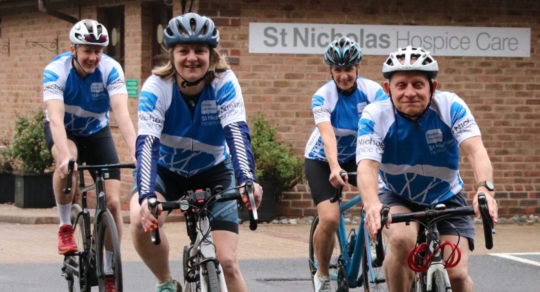 Cyclists wearing St Nic's jerseys outside the Hospice