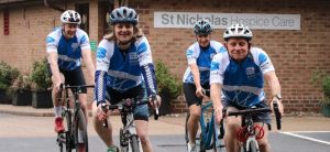 Cyclists wearing St Nic's jerseys outside the Hospice