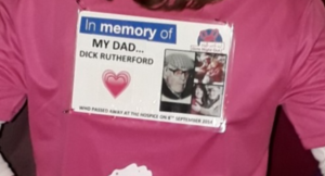 Close-up of a pink ‘Girls Night Out’ charity T-shirt featuring a memorial badge for Dick Rutherford.
