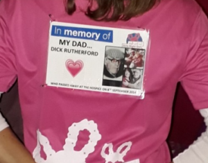 Close-up of a pink ‘Girls Night Out’ charity T-shirt featuring a memorial badge for Dick Rutherford.