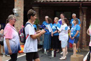 Sunset Walk participants walking past the Hospice with St Nic's Sings in the background