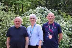 Image showing three people. Gerry Newcombe who has received support for the hospice, Sarah from the Hospice's Patient and Family Support Team and Gerry's brother Colin Newcombe who ran the marathon for the hospice